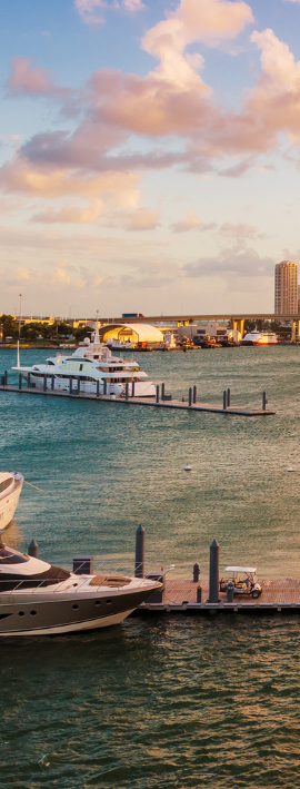 Modern living room with a kitchen, large windows, and various seating areas.