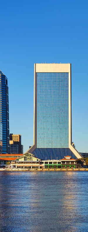 Modern living room with neutral colors, fireplace, large windows, and open staircase.