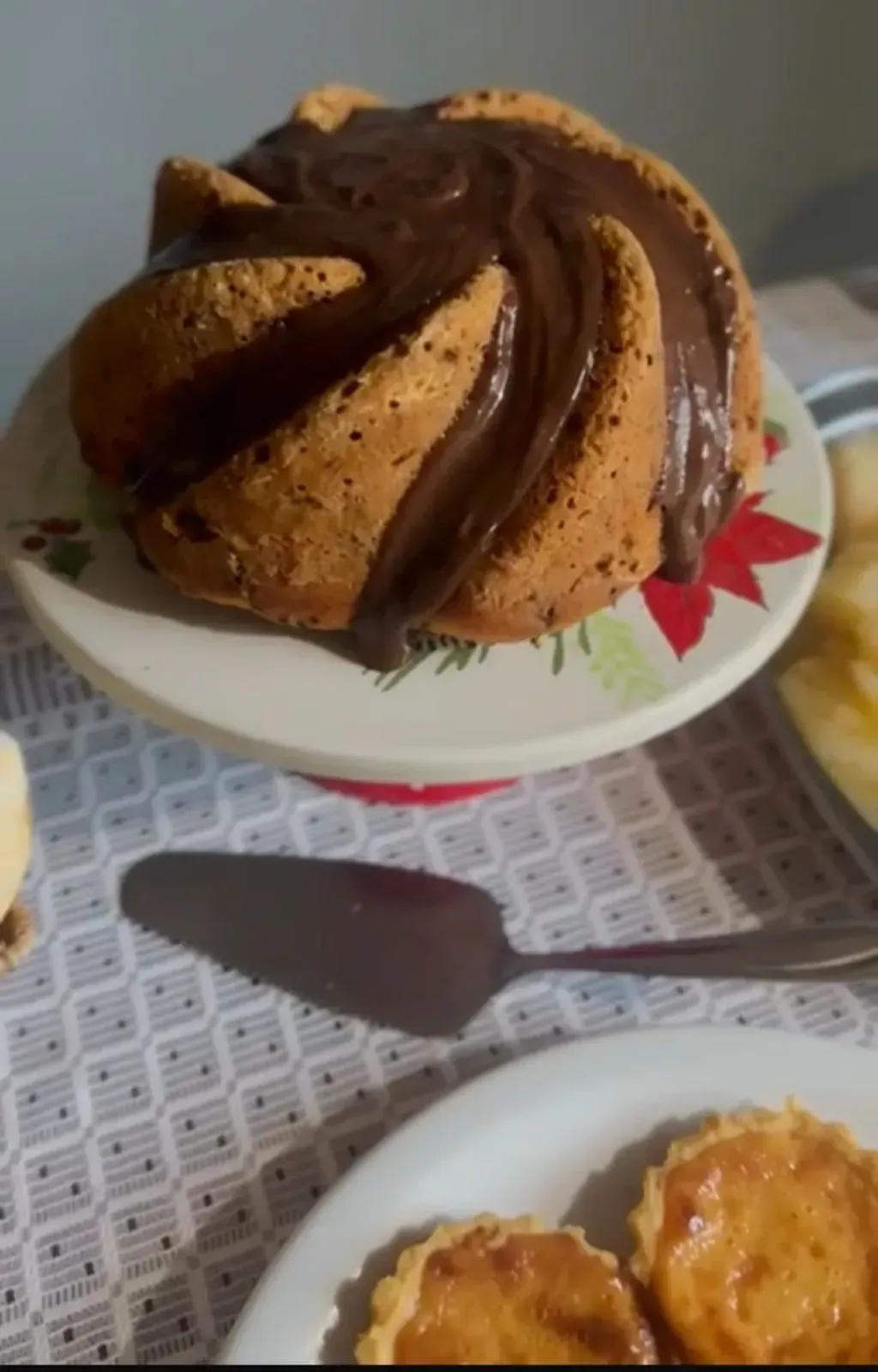 Um bolo bundt com cobertura de chocolate em um prato branco Pousada Golfinho Fernando de Noronha