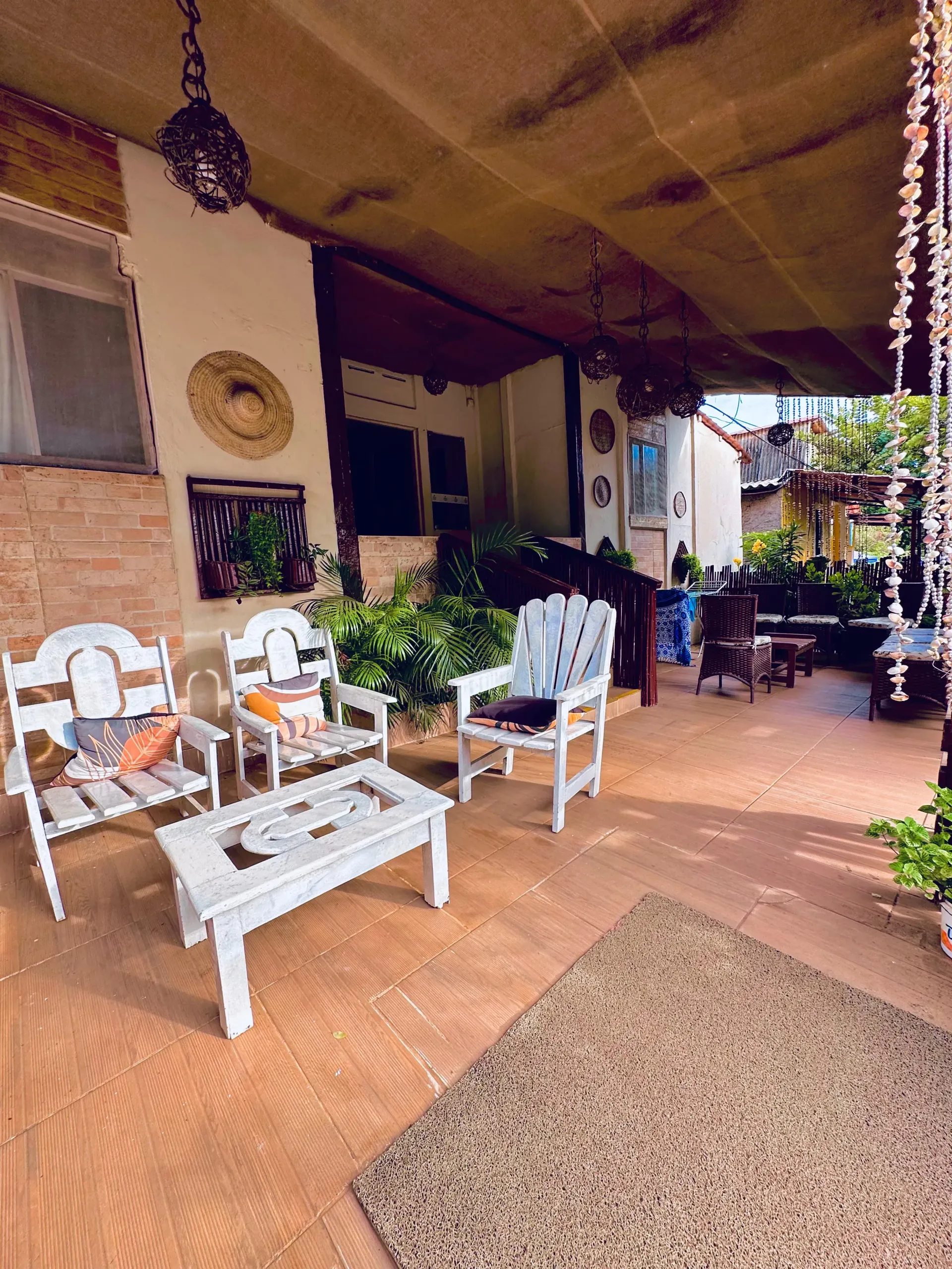 Há muitas cadeiras e mesas na varanda. Pousada Golfinho Fernando de Noronha