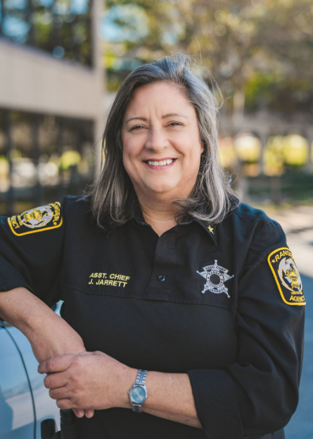 A woman in a sheriff 's uniform is smiling for the camera