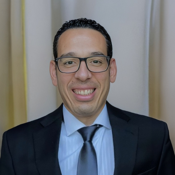 A man in a suit and tie smiles for the camera