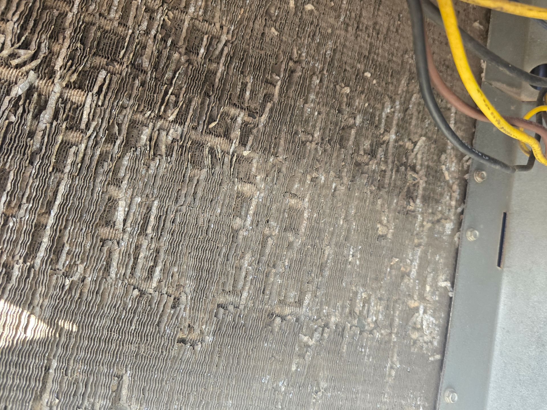 American Air Services, LLC - Dirty, outdoor air conditioner coil. The coil has visible dust and debris.