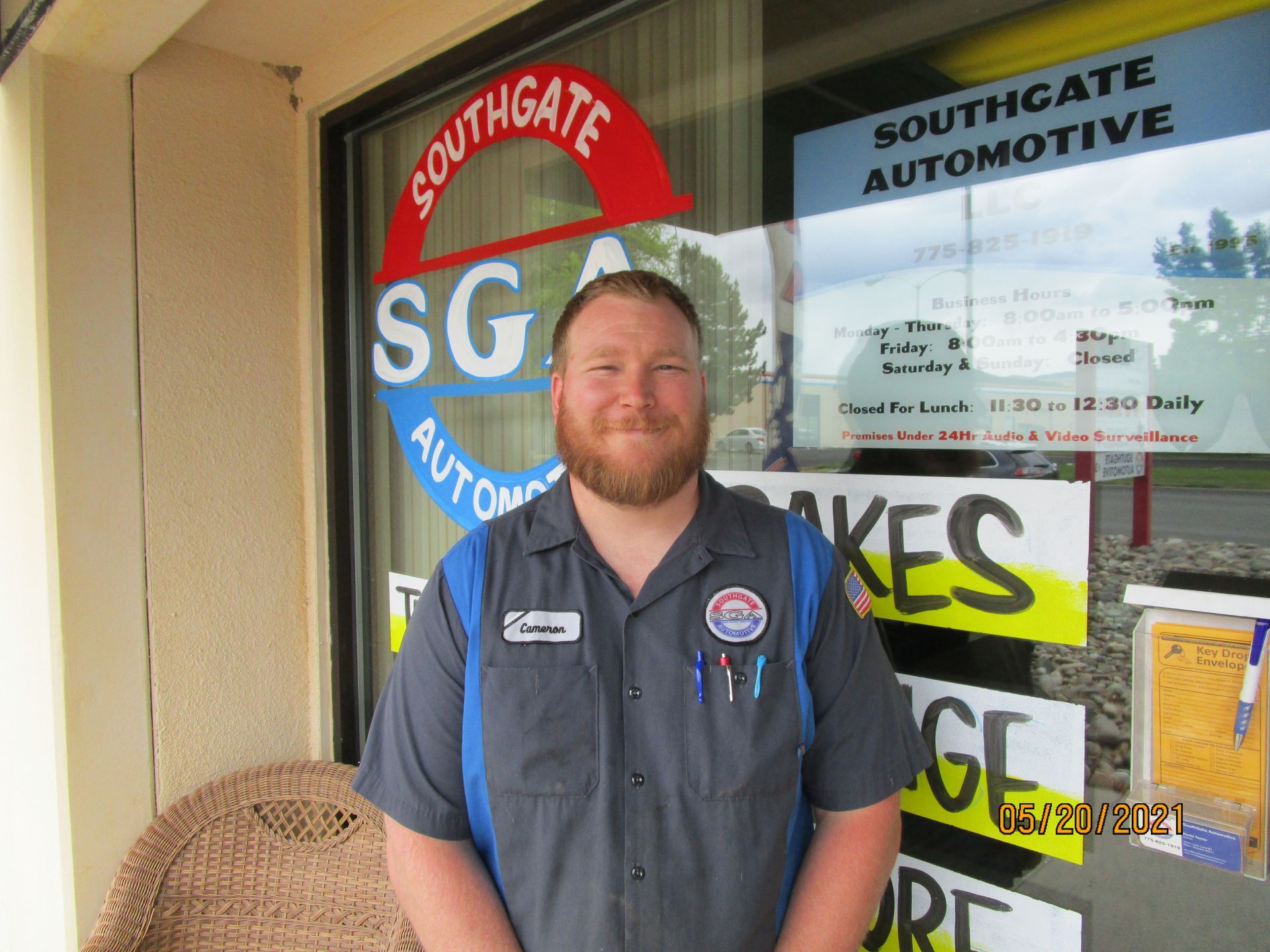 Man in a mechanic's uniform stands in front of a Southgate Automotive sign. | Southgate Automotive