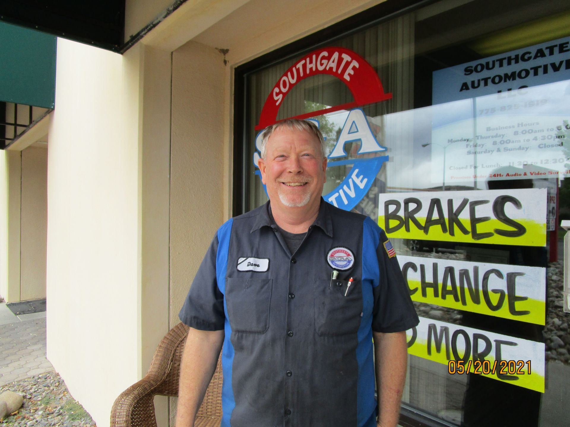 Man in blue shop uniform in front of 