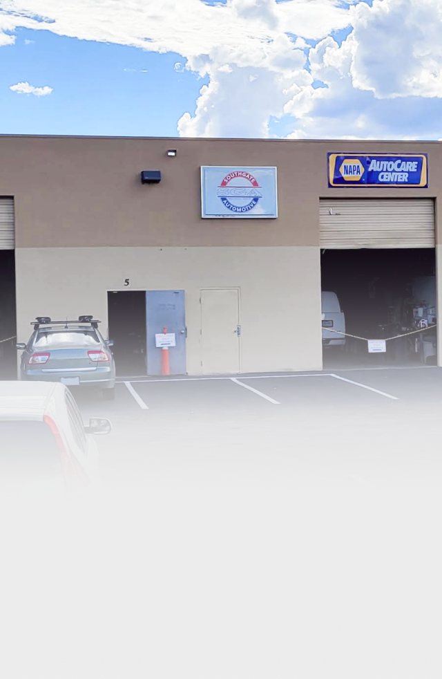 Auto repair shop exterior with car, blue sky, and