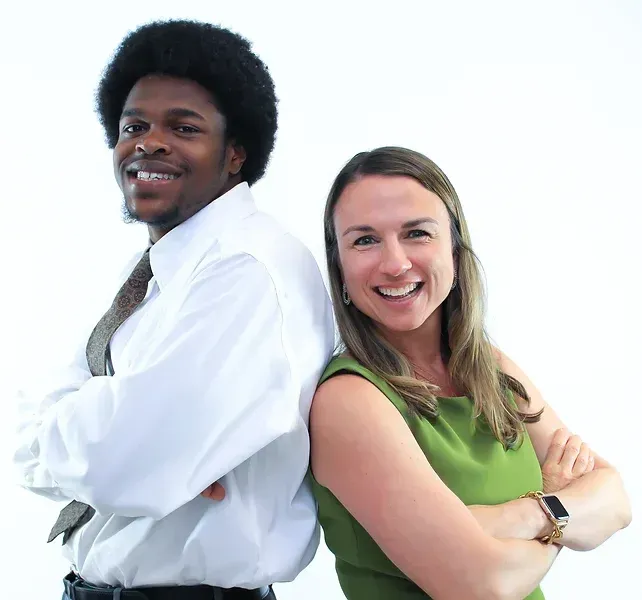 A man and a woman standing back to back with their arms crossed