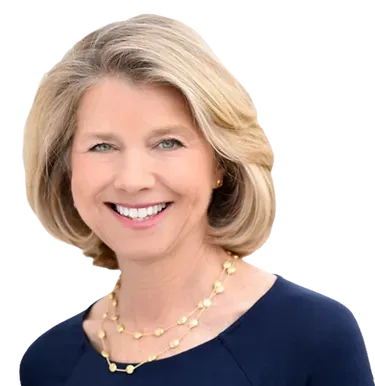 A woman wearing a blue shirt and a gold necklace is smiling.