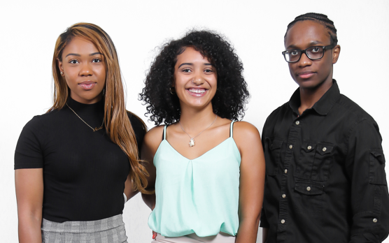 A man and two women are posing for a picture together