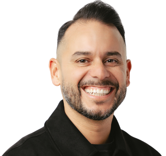 A man with a beard is wearing a suit and smiling.