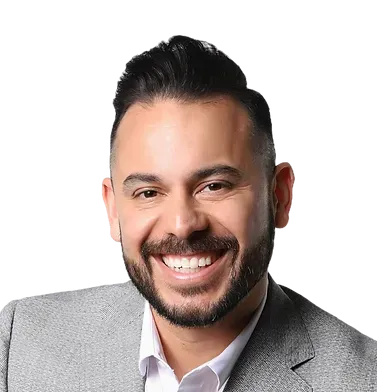 A man with a beard is wearing a suit and smiling.