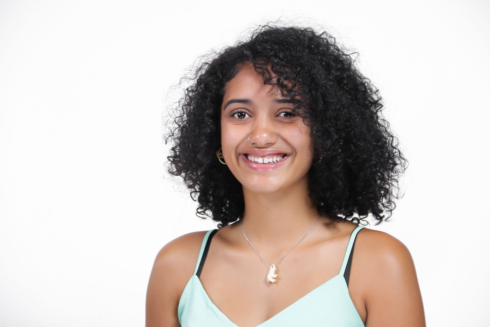 A young woman with curly hair is smiling for the camera.