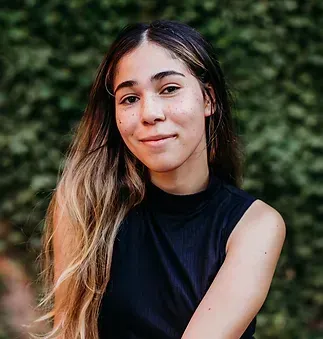 The woman is wearing a black tank top and smiling for the camera.