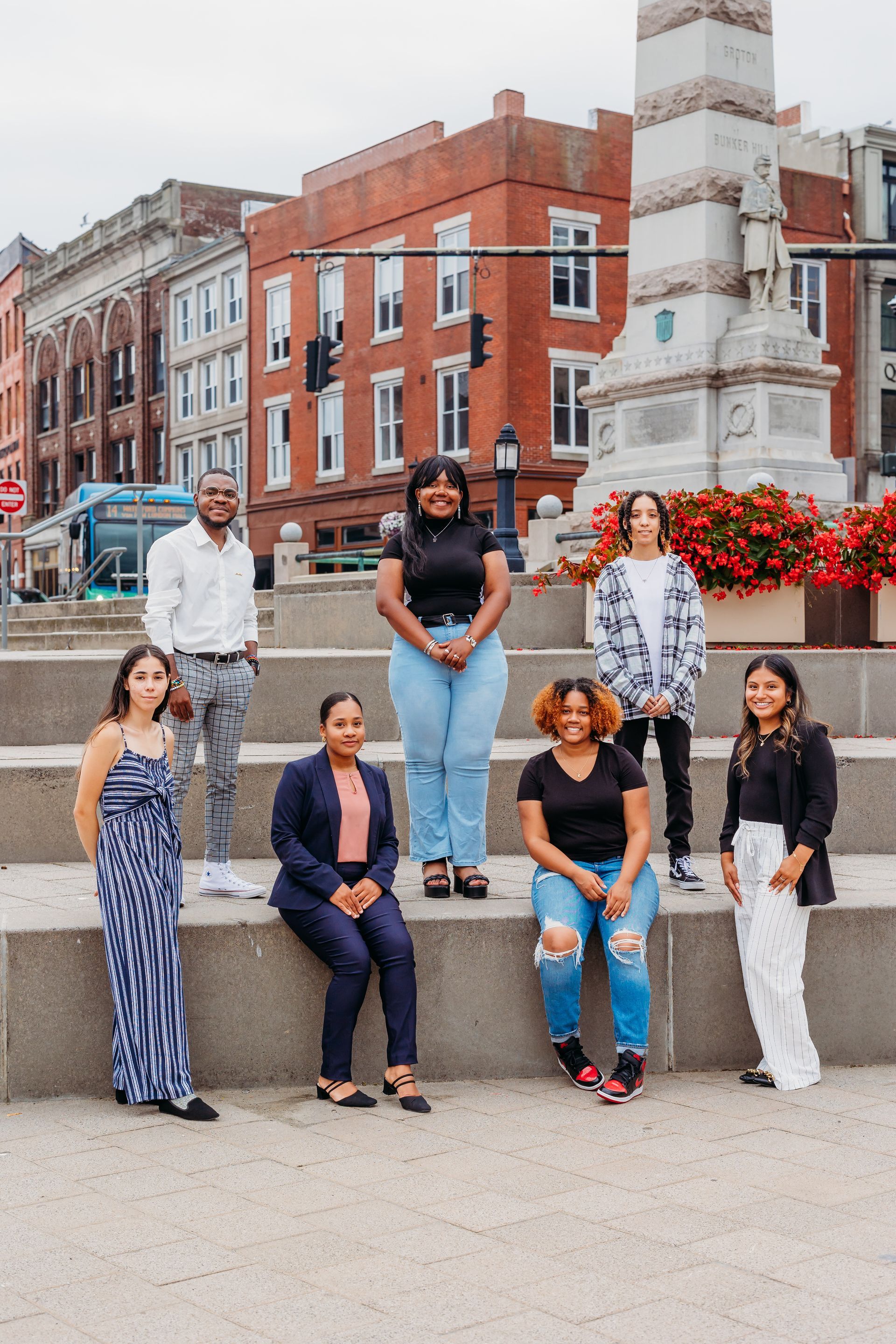 A group of people are posing for a picture in front of a brick building.