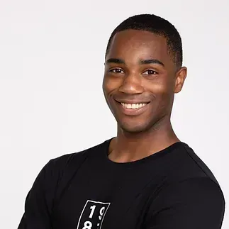 A young man in a black shirt is smiling for the camera.