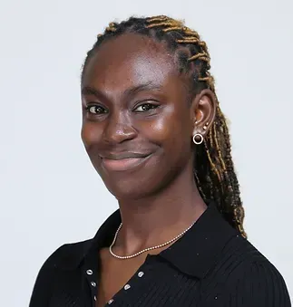 A woman wearing a black shirt and earrings is smiling for the camera.
