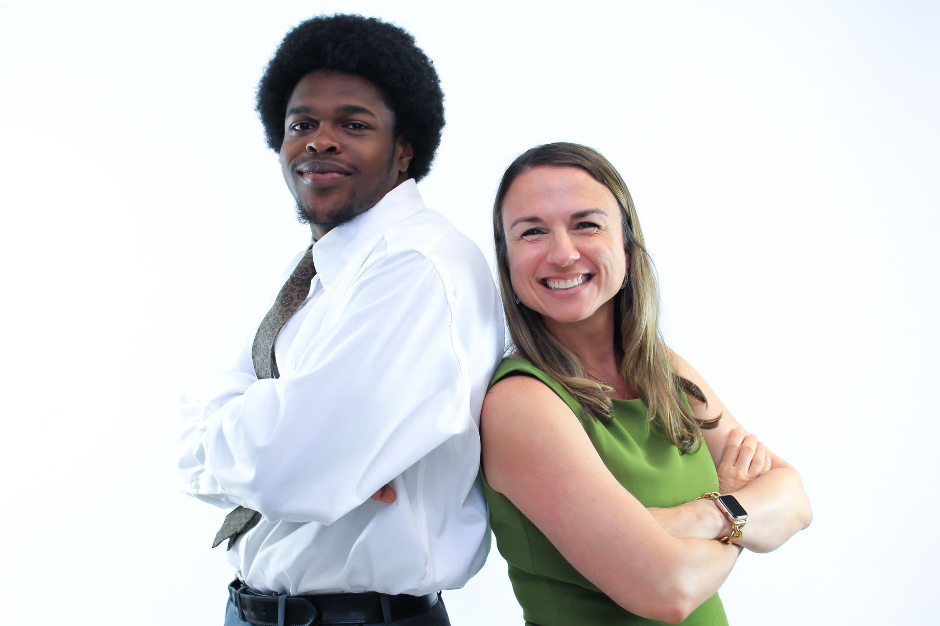 A man and a woman standing back to back with their arms crossed
