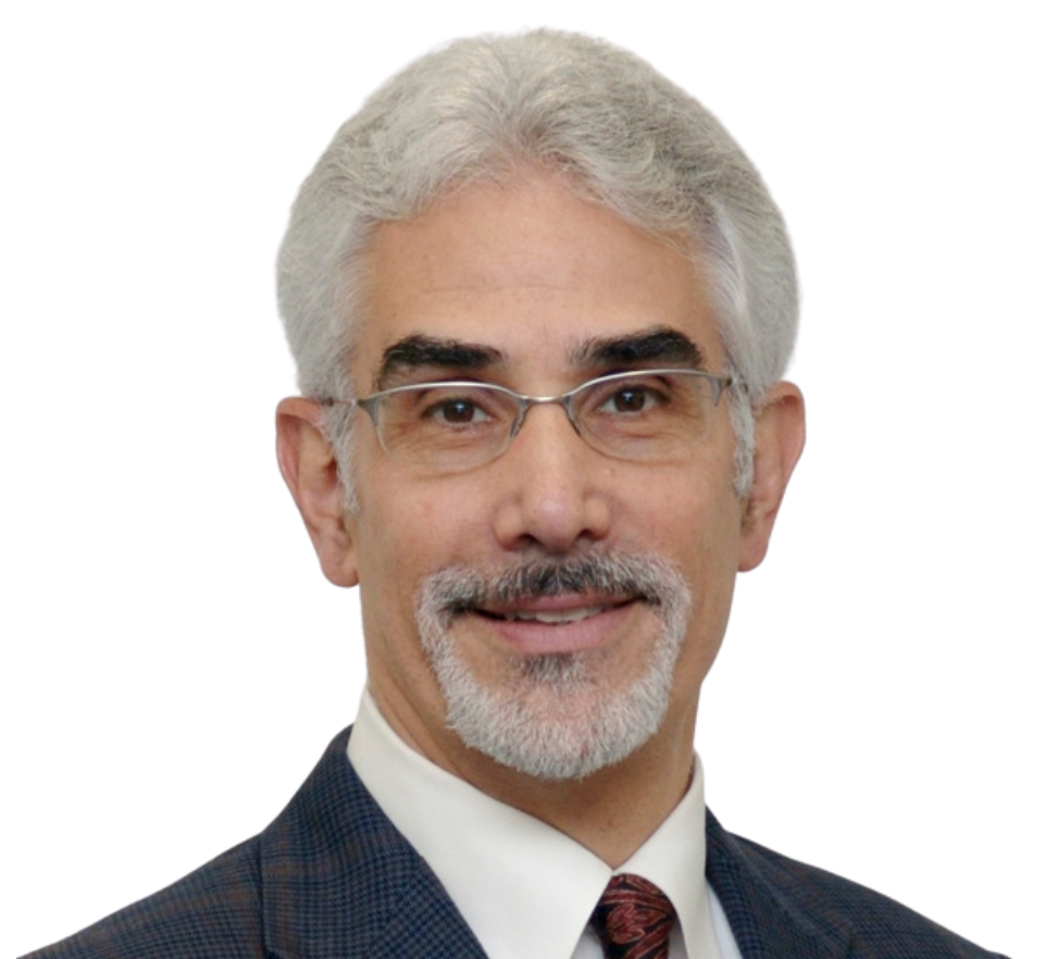 Man with glasses, gray hair and beard, wearing a dark suit, smiling, neutral background.