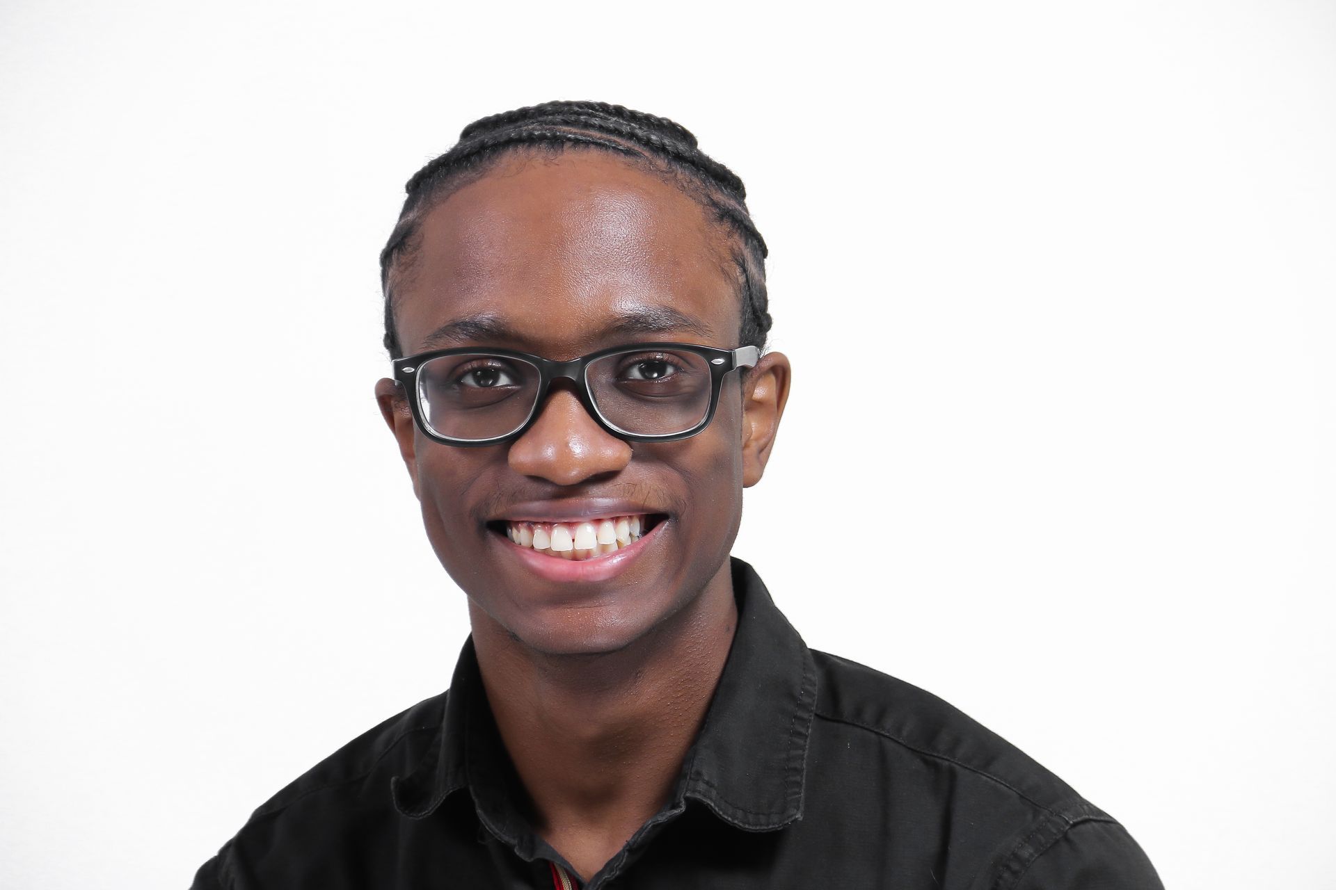 A young man wearing glasses and a black shirt is smiling for the camera.