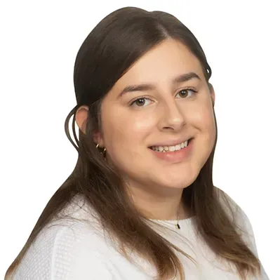 A woman in a white shirt is smiling for the camera.