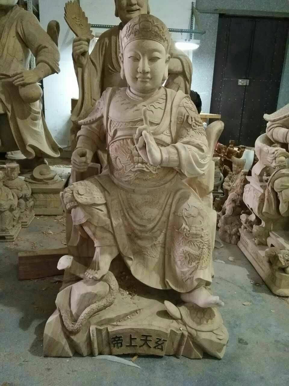 工作室裡擺放著一尊小型石雕神像,神像端坐在蓮花座上,底座上有漢字。