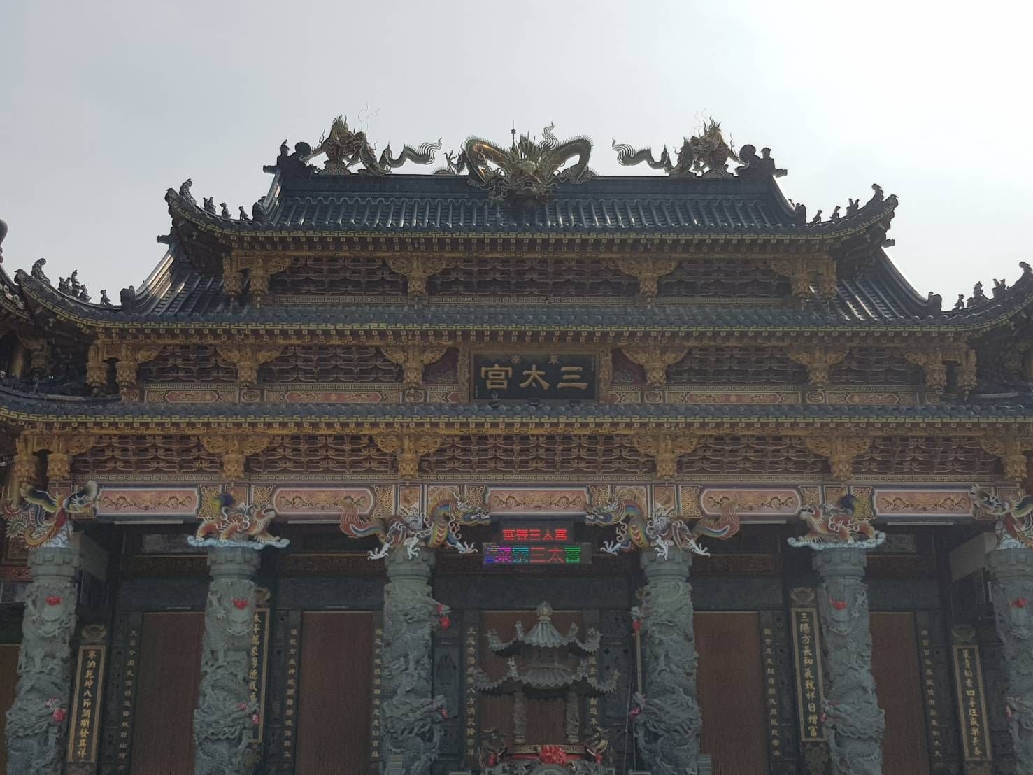 華麗的傳統寺廟大門,配有雕刻精美的柱子和色彩繽紛的屋頂裝飾