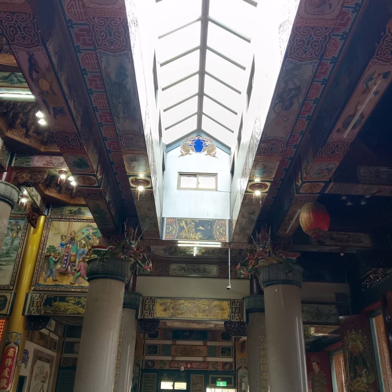 寺廟內部裝潢華麗,有彩繪的橫樑、柱子,上方還有明亮的天窗。