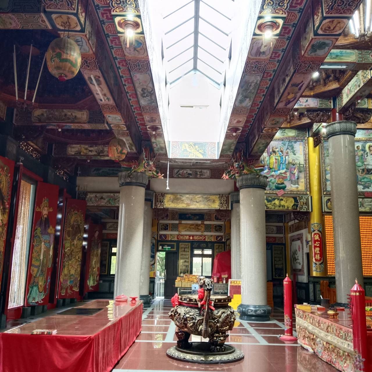 寺廟內部裝潢華麗,有紅色立柱、金色裝飾,中央祭壇上方設有天窗。