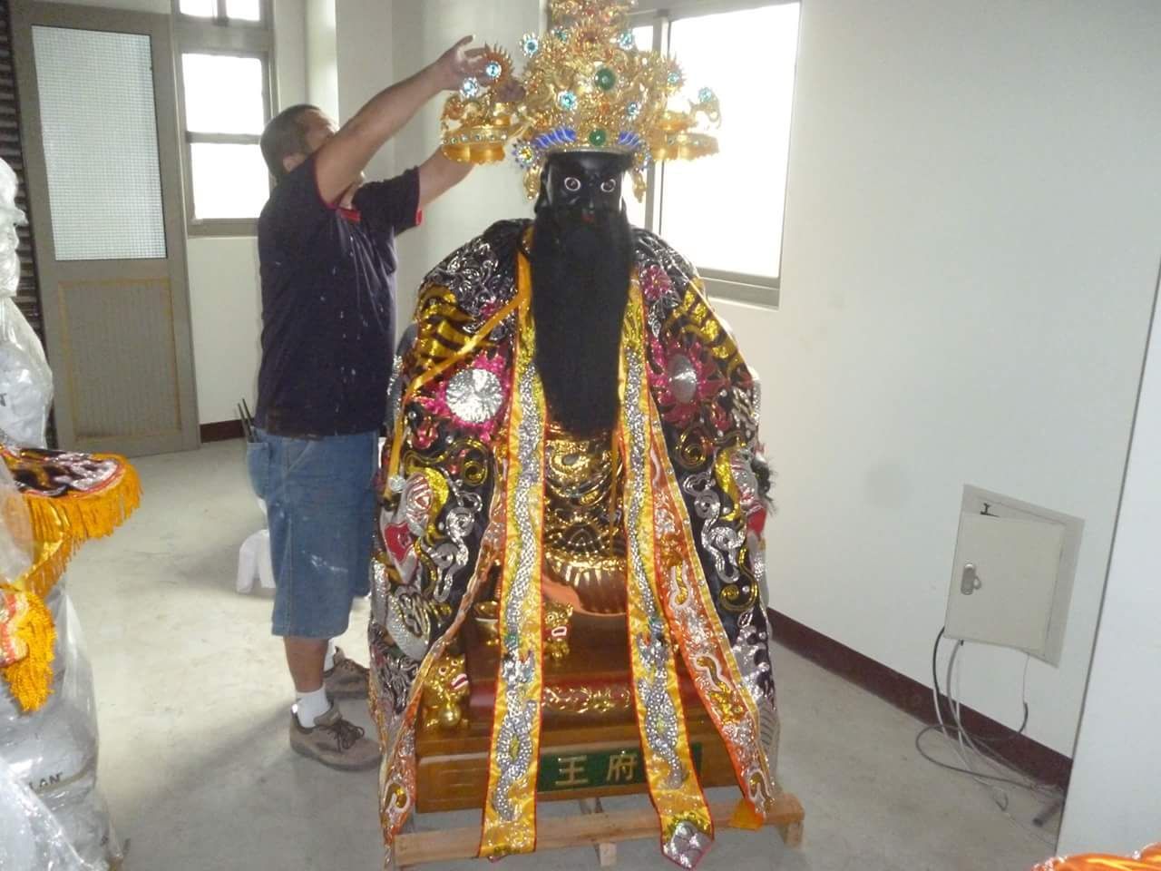 有人在走廊上裝飾色彩鮮豔、綴滿亮片的服裝或神龕雕像