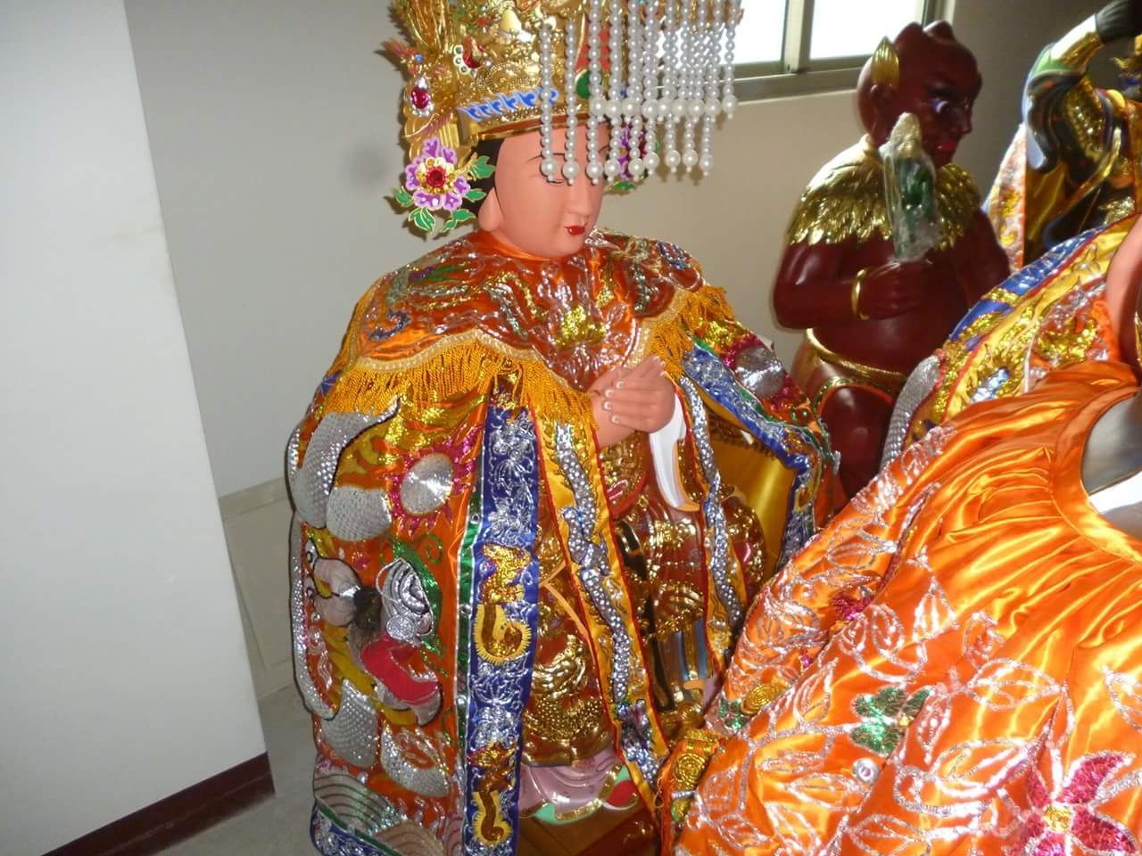 室內陳列著身穿亮橙色、金色和藍色長袍的裝飾精美的宗教雕像