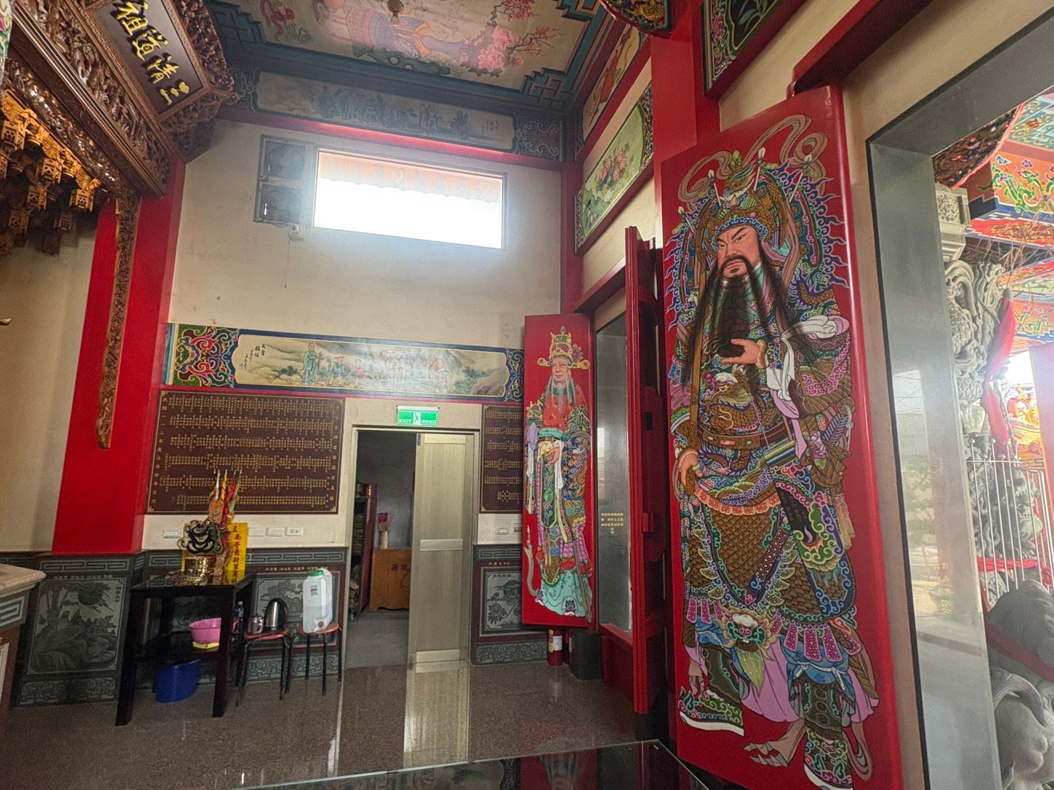 寺廟內部裝潢華麗,有紅色立柱、色彩鮮豔的神像壁畫、高窗和敞開的大門。