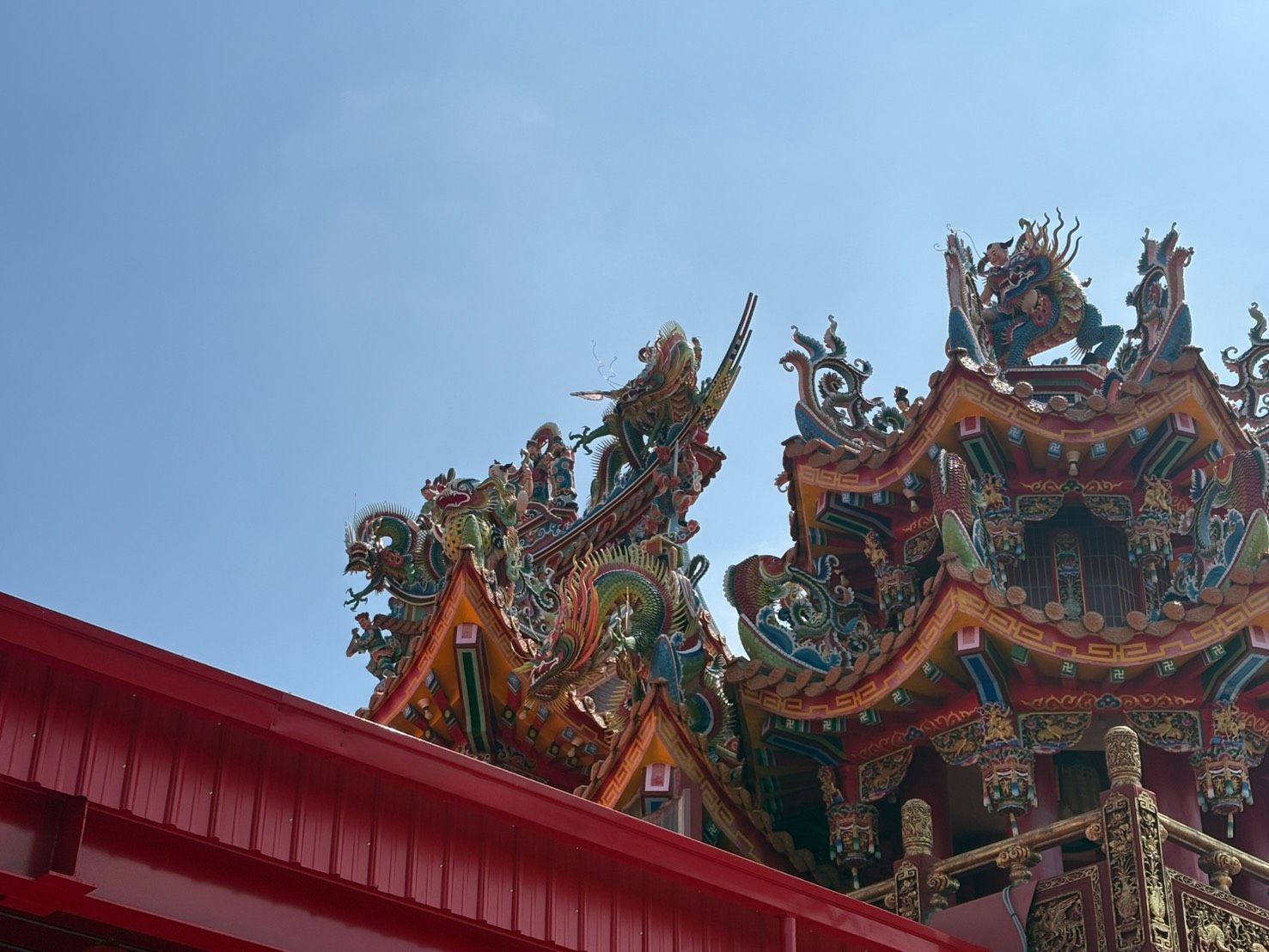 湛藍的天空映襯著華麗的中國寺廟屋頂,上面雕刻著色彩繽紛的龍。