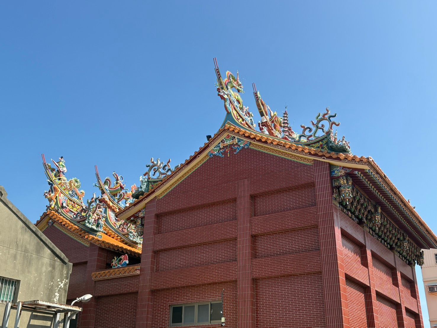 湛藍的天空映襯著裝飾華麗的金色屋頂,一座傳統的中國寺廟映襯著湛藍的天空。