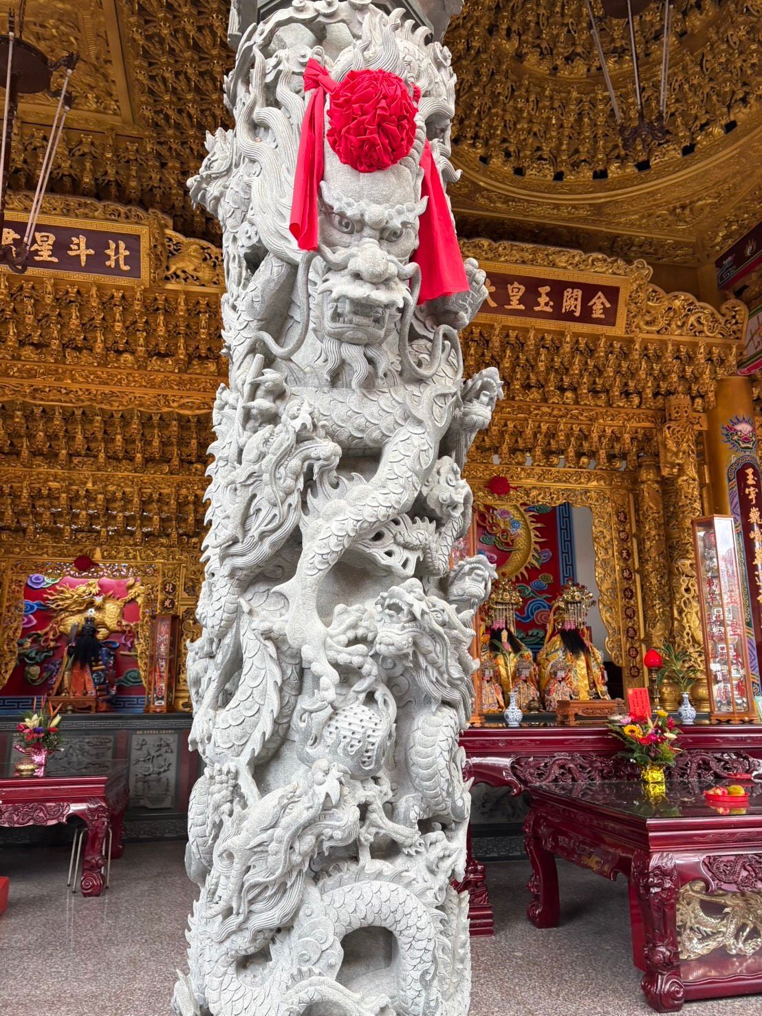 華麗的金色寺廟大廳內,一根白色雕花柱垂著紅色流蘇。