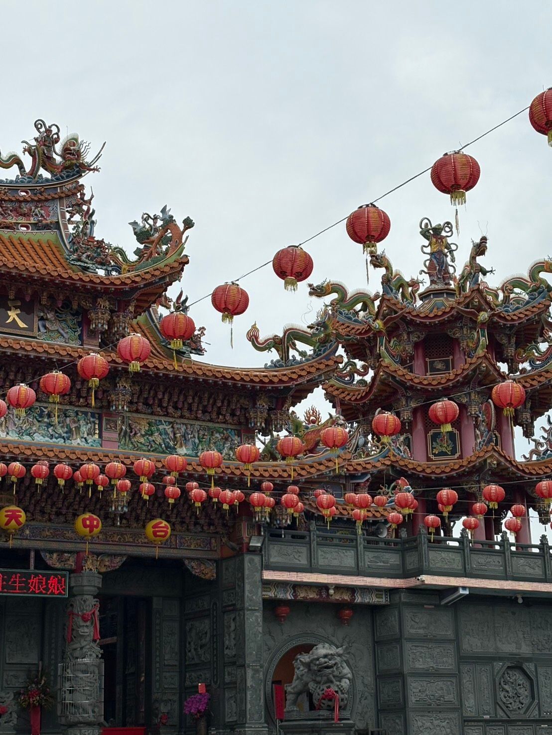 傳統的中國寺廟,屋頂雕刻精美,頭頂懸掛著紅色燈籠。
