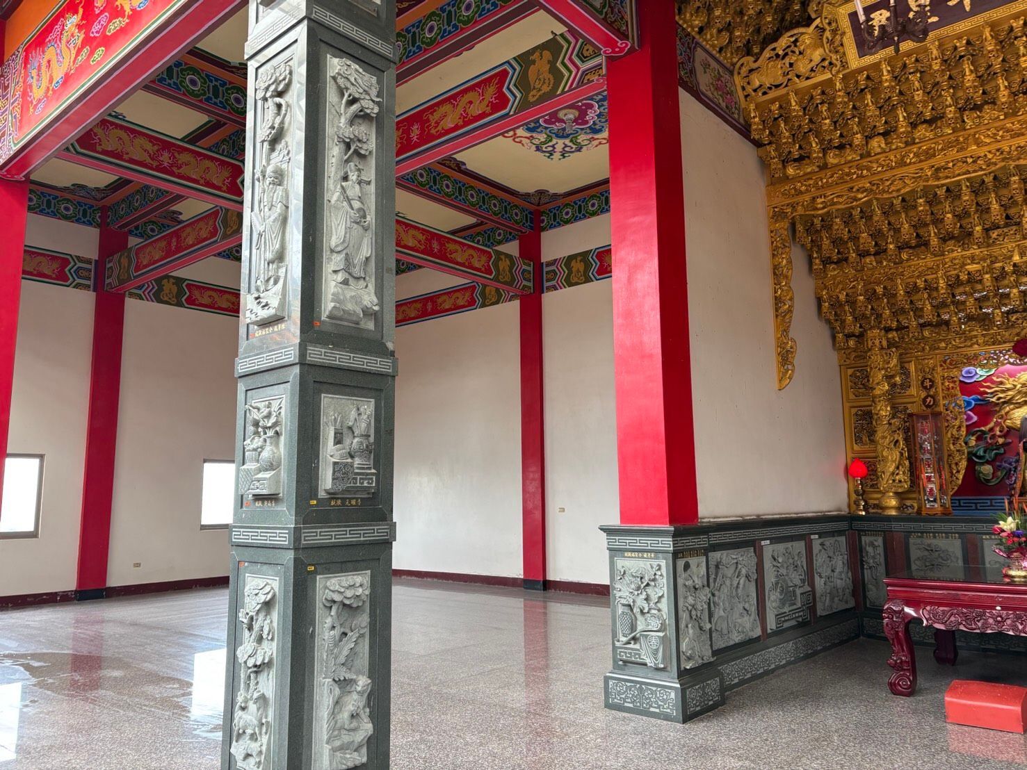 寺廟內部裝潢華麗,有紅金相間的柱子、雕刻精美的石柱和裝飾華麗的天花板。