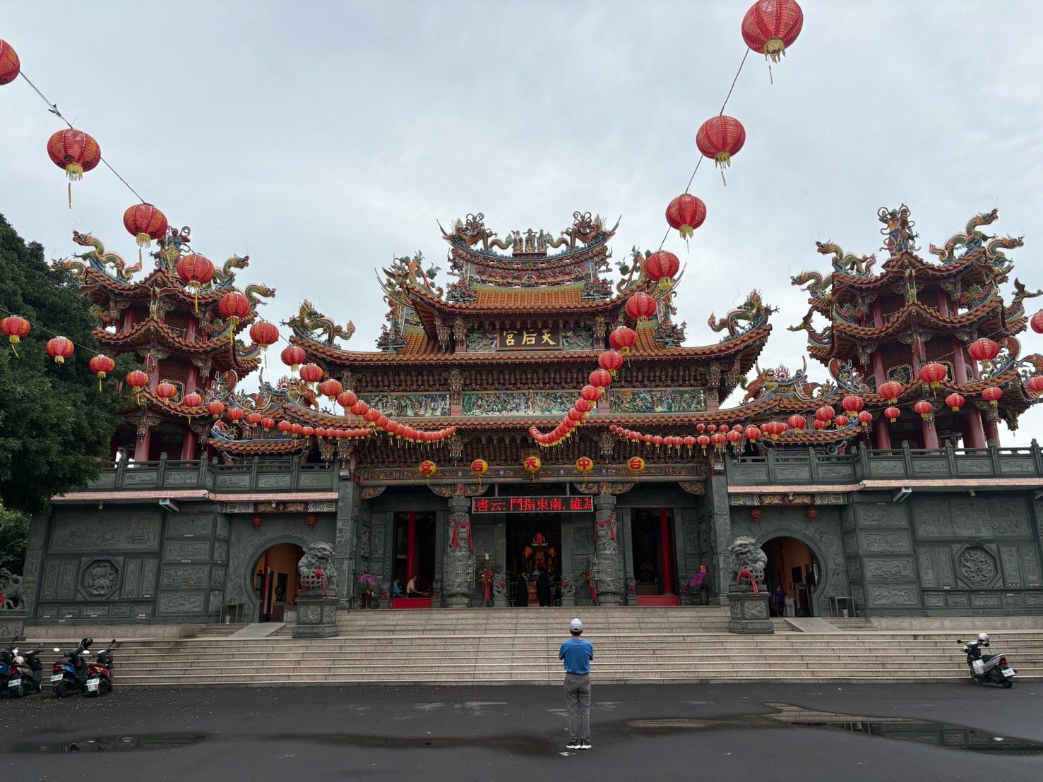 從空曠的庭院望去,可以看到寺廟入口處掛著紅燈籠,屋頂裝飾華麗。
