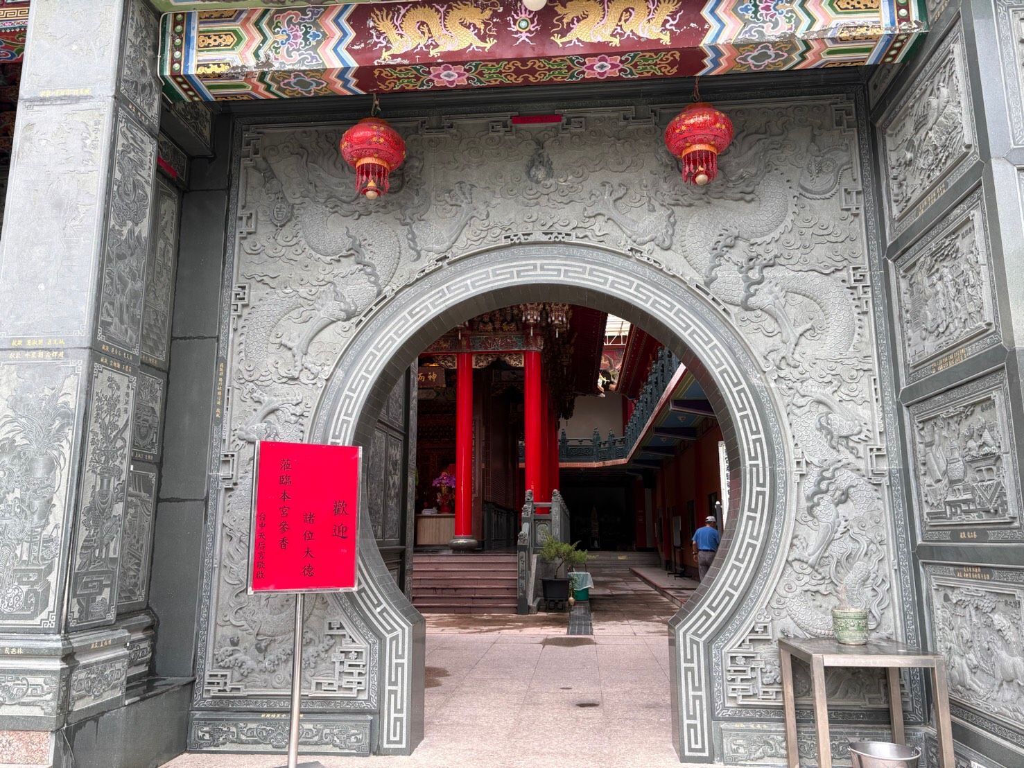 精美的石砌寺廟入口,掛著紅燈籠,圓形門通往內部。