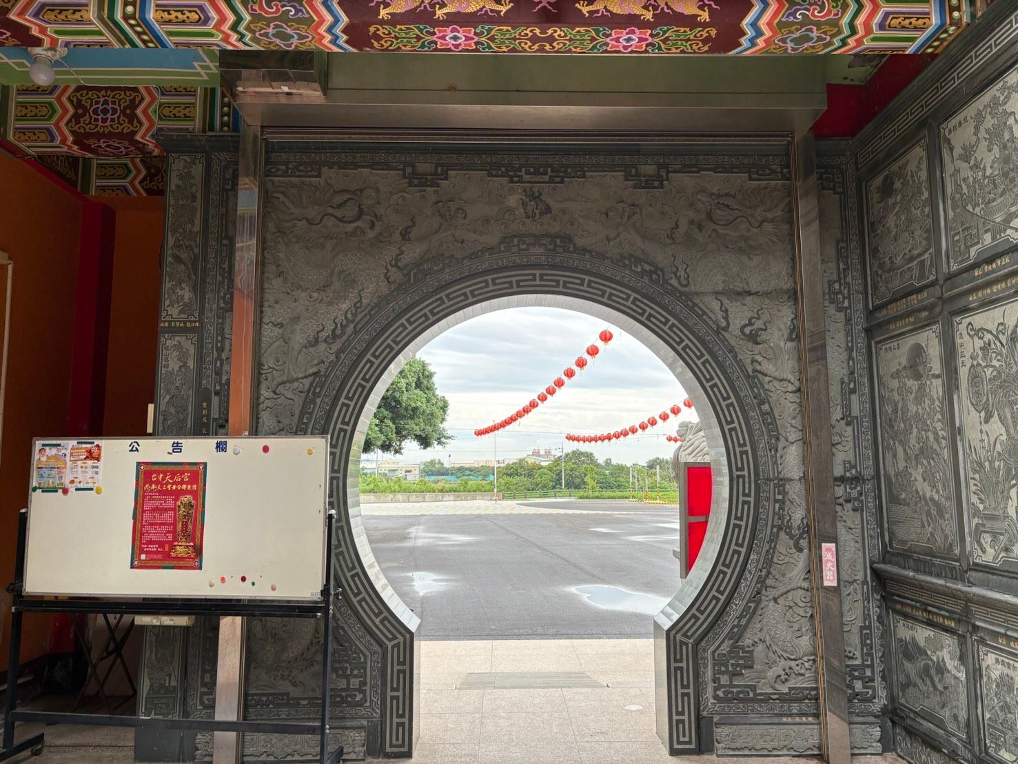 華麗的石拱門通往街道,外面掛著紅燈籠,裡面有招牌。