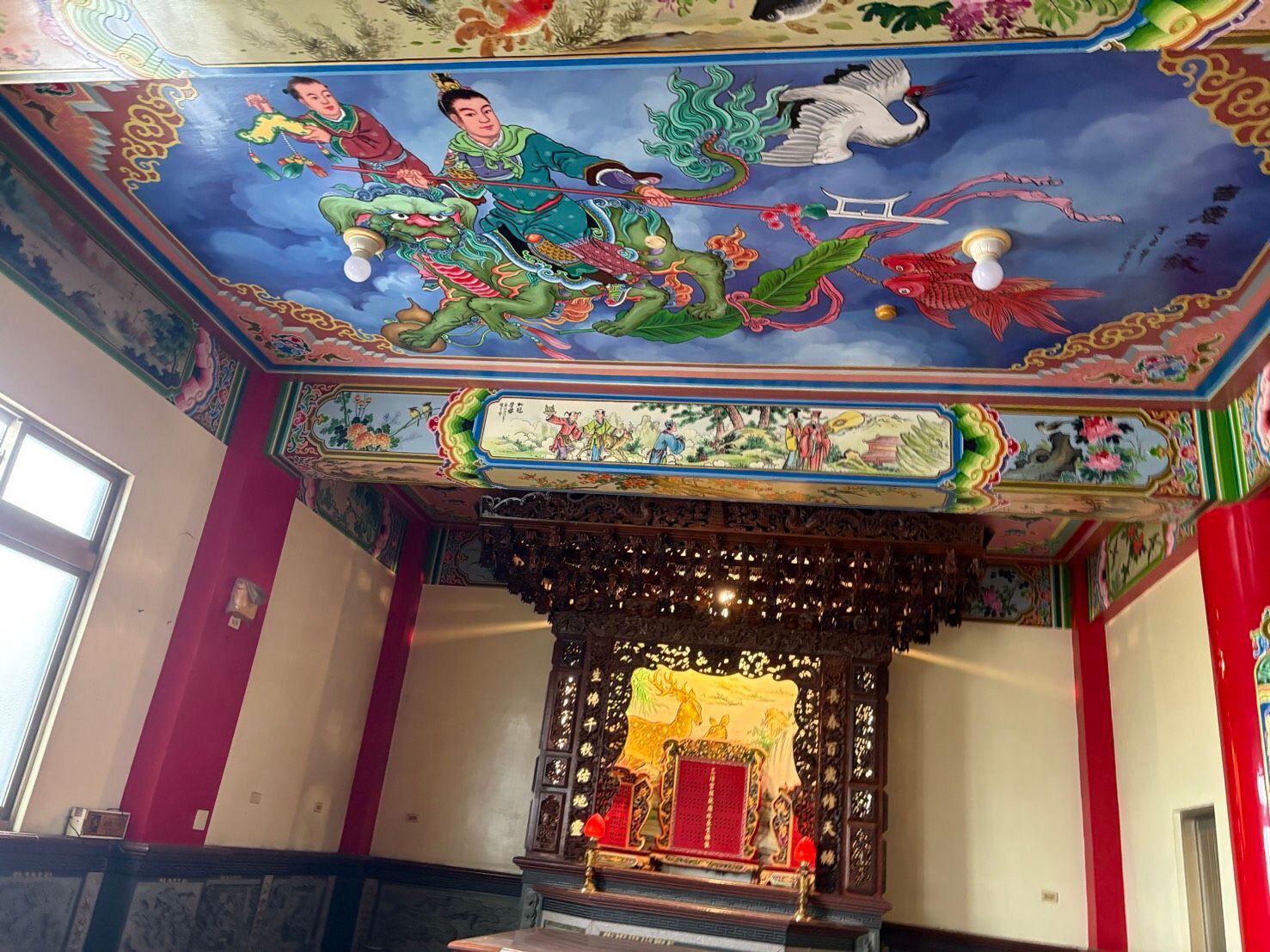 寺廟內部裝飾華麗,天花板繪有彩繪,祭壇精美,後部設有紅金相間的佛龕。