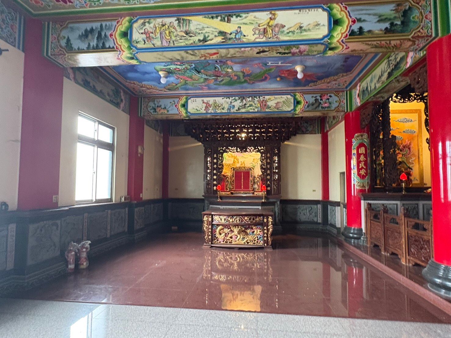 色彩斑斕、裝飾華麗的寺廟大殿,中央設有祭壇,天花板繪有彩繪,紅色立柱,地面光潔如鏡。