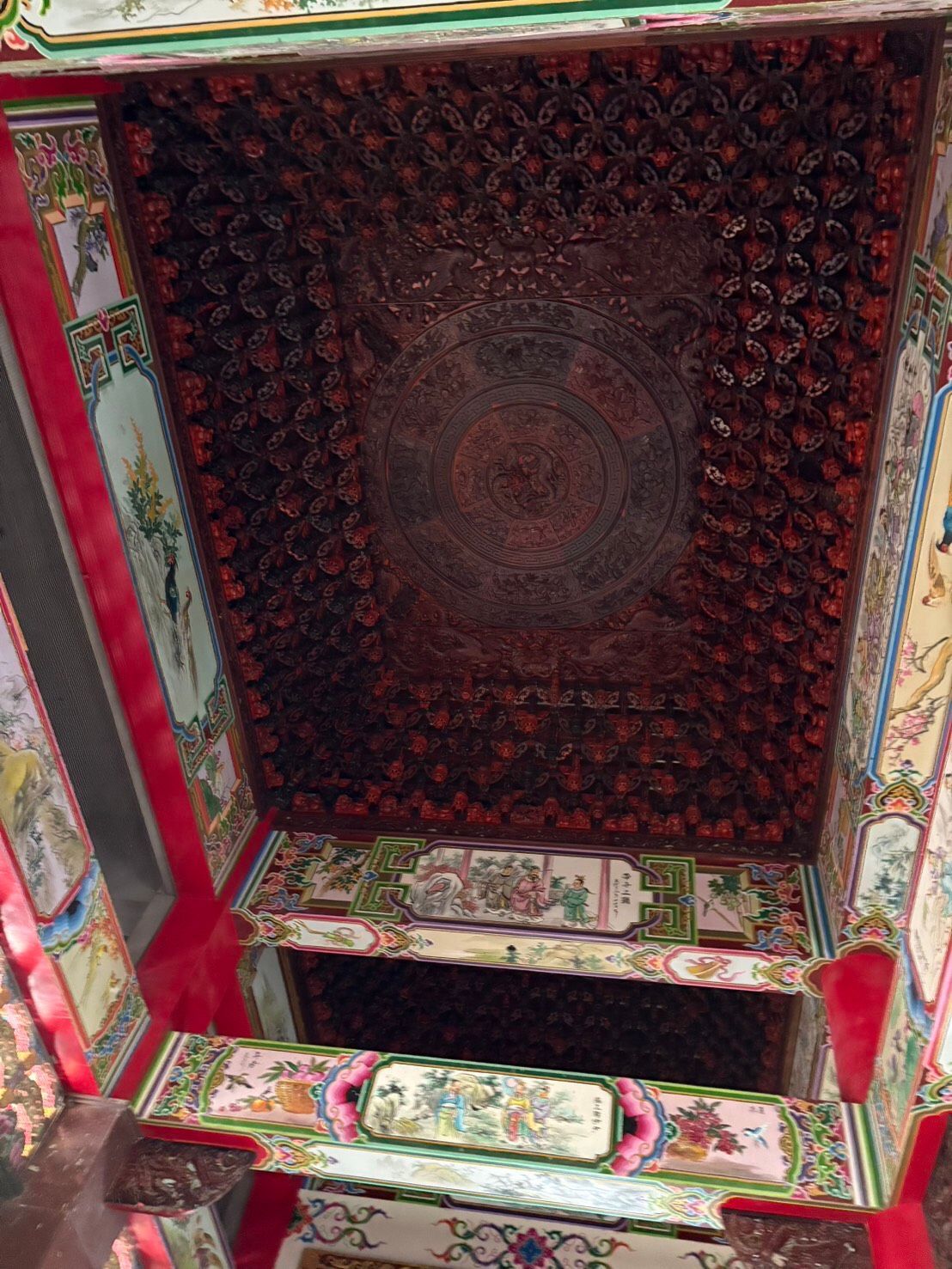 歷史建築內部裝飾華麗的彩繪天花板,飾有紅色、綠色和花卉圖案的裝飾板。