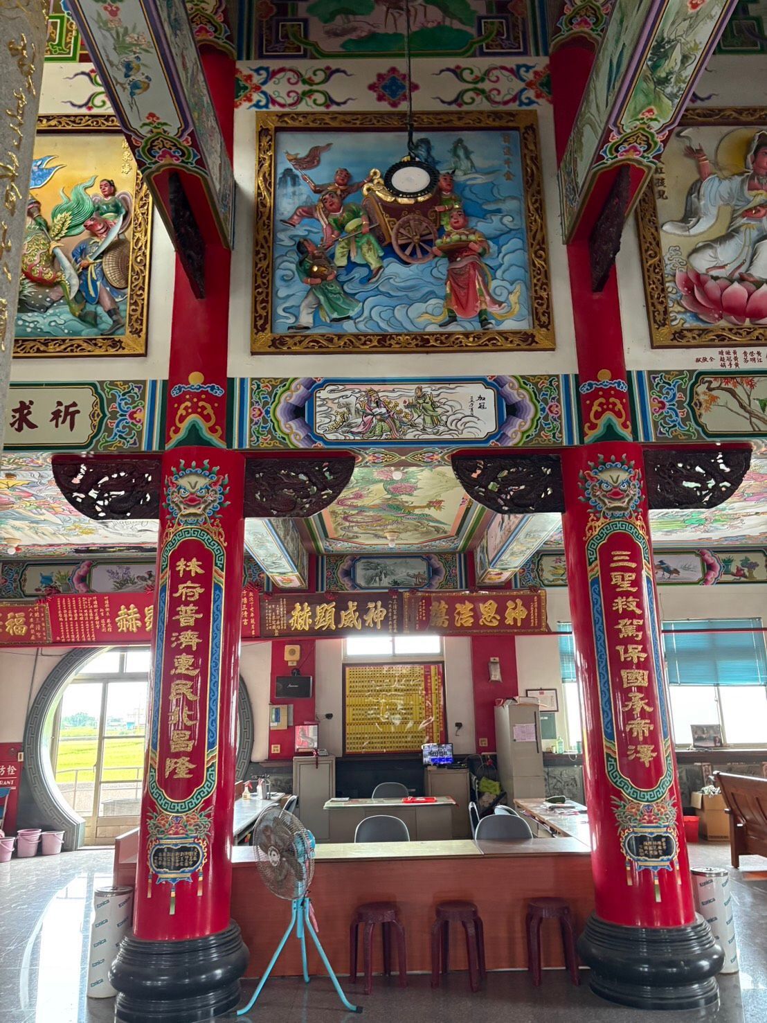 裝飾華麗的寺廟祭壇,配有紅色立柱、懸掛的捲軸和精美的彩繪天花板。