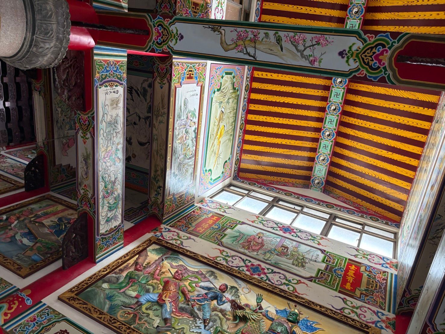 裝飾精美的寺廟內部,天花板、柱子以及地板和牆板上都繪有色彩繽紛的圖案。