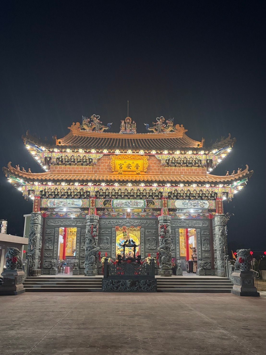 夜晚,燈光璀璨,裝飾華麗的寺廟顯得格外引人注目,寬闊的正面台階也引人注目。