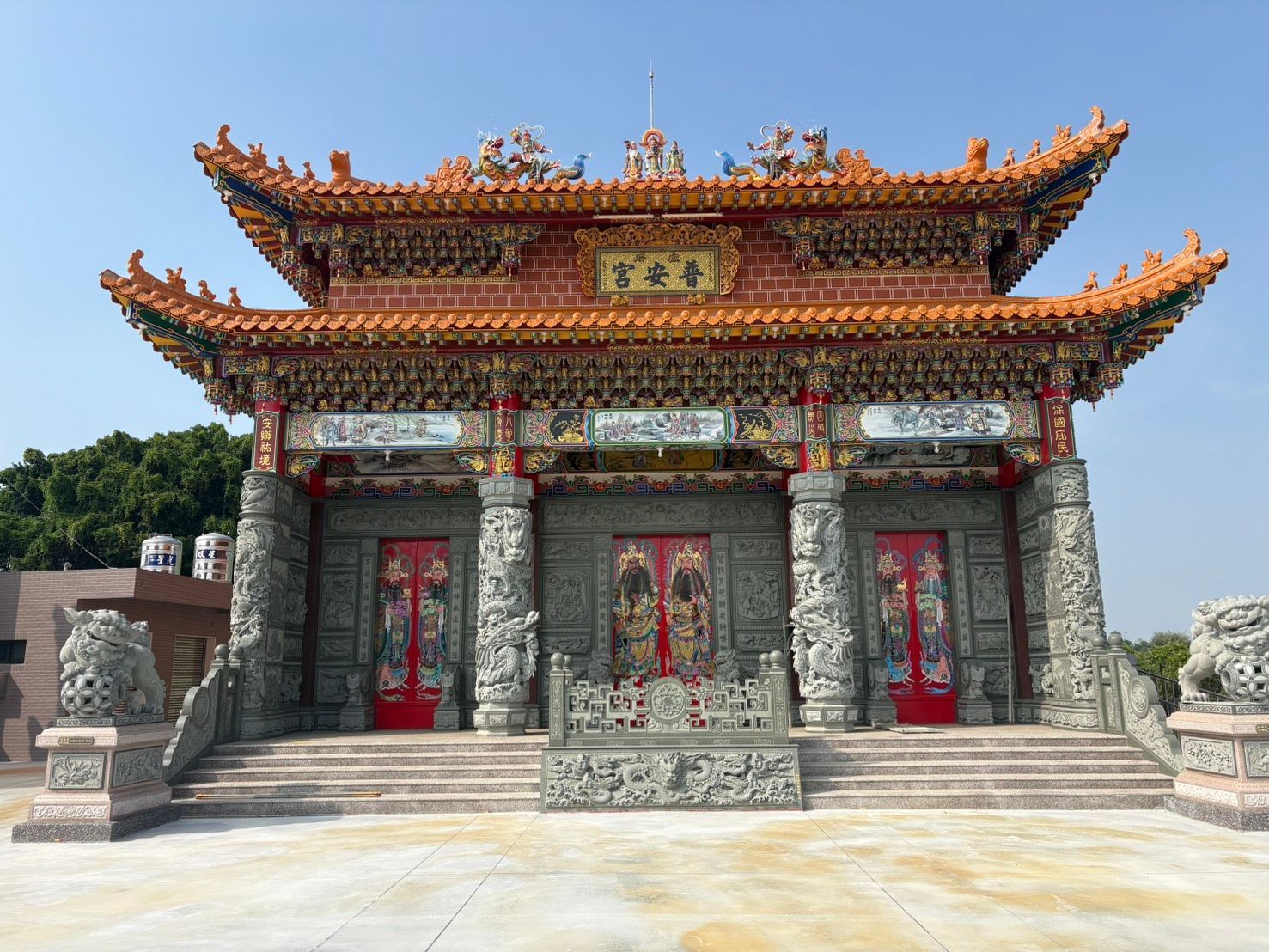 晴空之下,一座傳統的中國寺廟映入眼簾,它有著華麗的紅金屋頂和雕花石砌外牆。