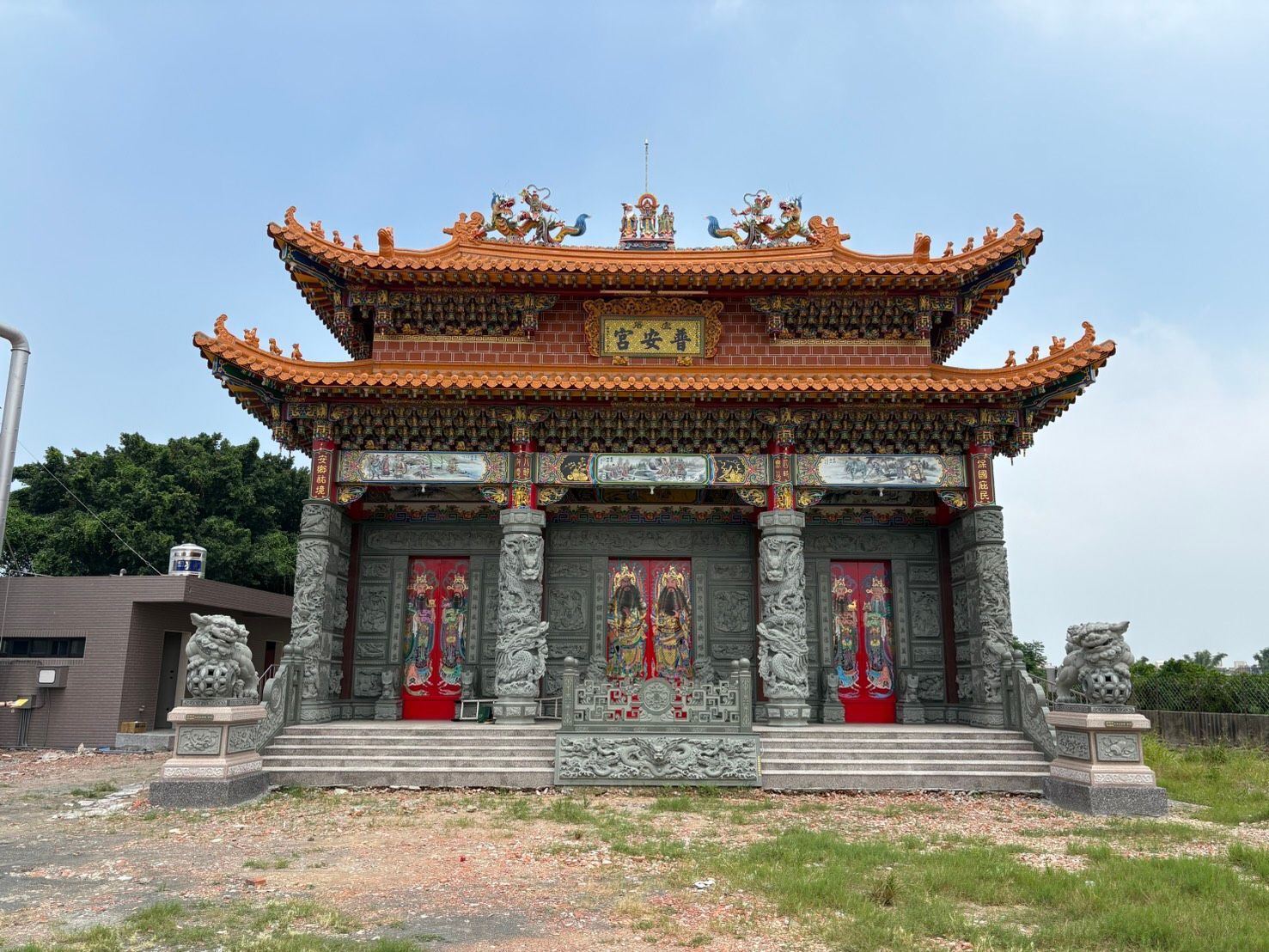 藍天下,一座裝飾華麗的傳統寺廟,紅門石柱錯落有致。