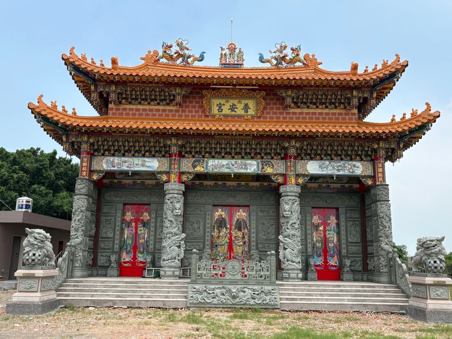 晴空之下,一座傳統的中國寺廟巍然屹立,紅金相間的屋頂和石牆閃閃發光。