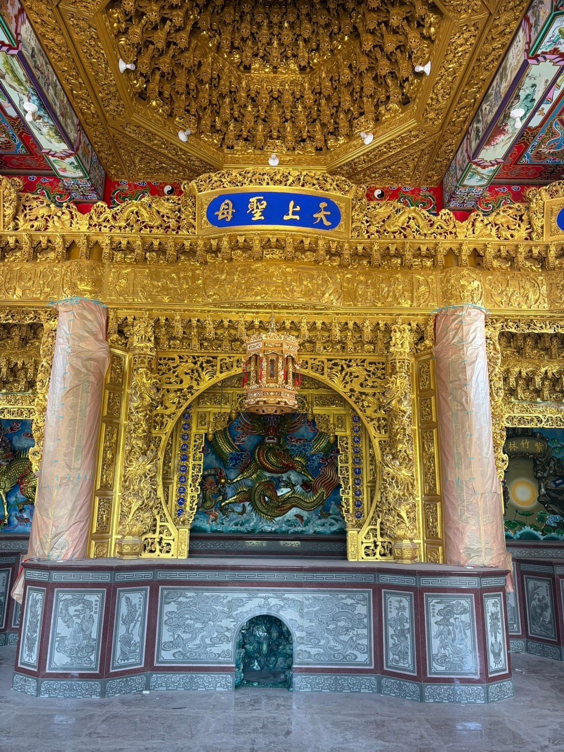 華麗的金色神龕內部,飾有雕花立柱、藍色匾額和裝飾精美的祭壇壁龕。