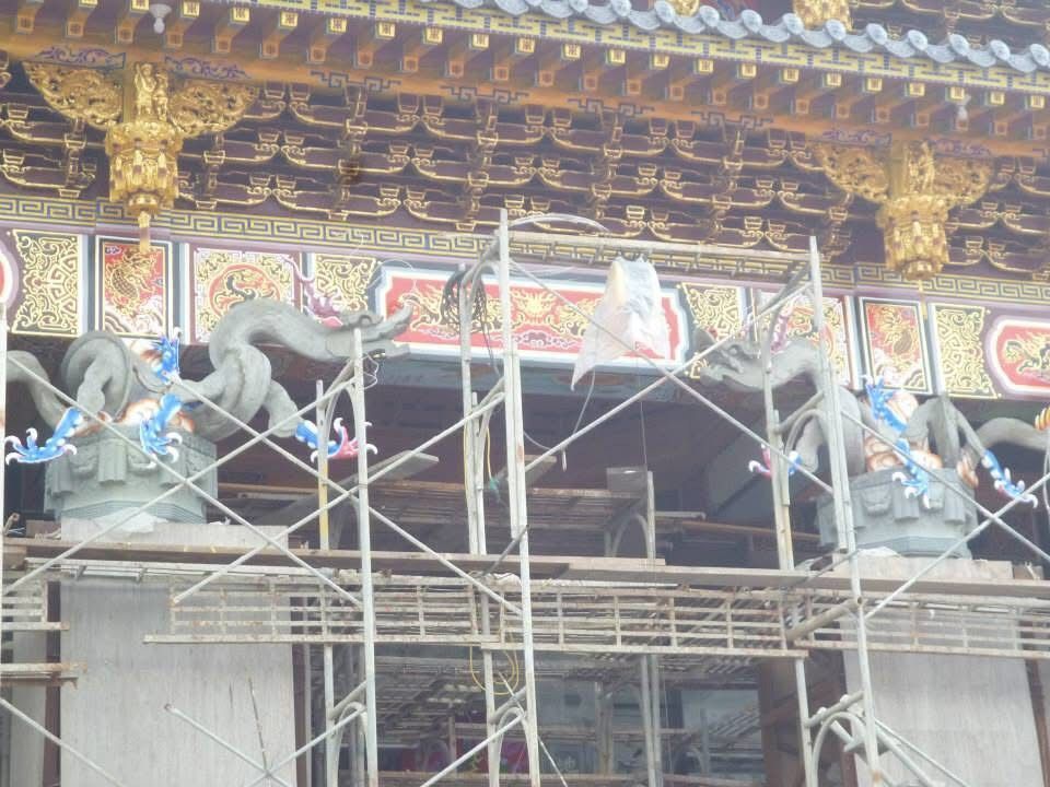 華麗的寺廟正面搭起了鷹架,正面雕刻著人物形象,屋頂飾有金色鑲邊。